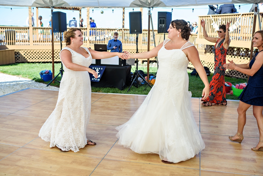 A bride spins her wife during their first dance as a married couple.